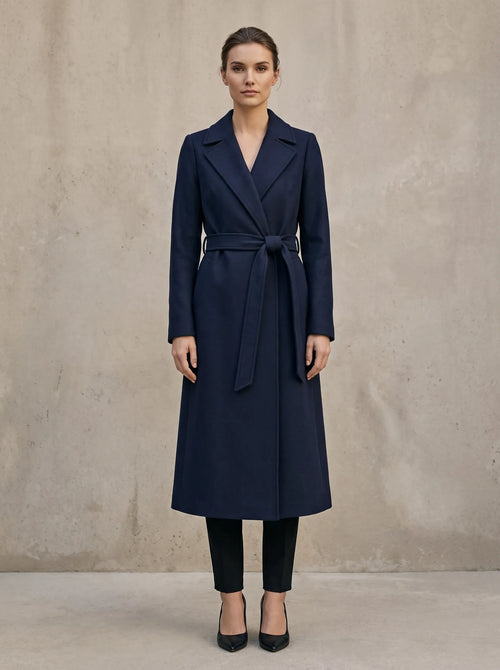 Margaux lange wikkelmantel met riem in navy, gedragen door model, vooraanzicht