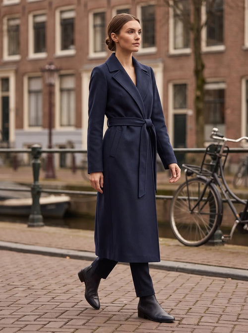 Margaux navy wikkelmantel gedragen op straat langs Amsterdamse gracht