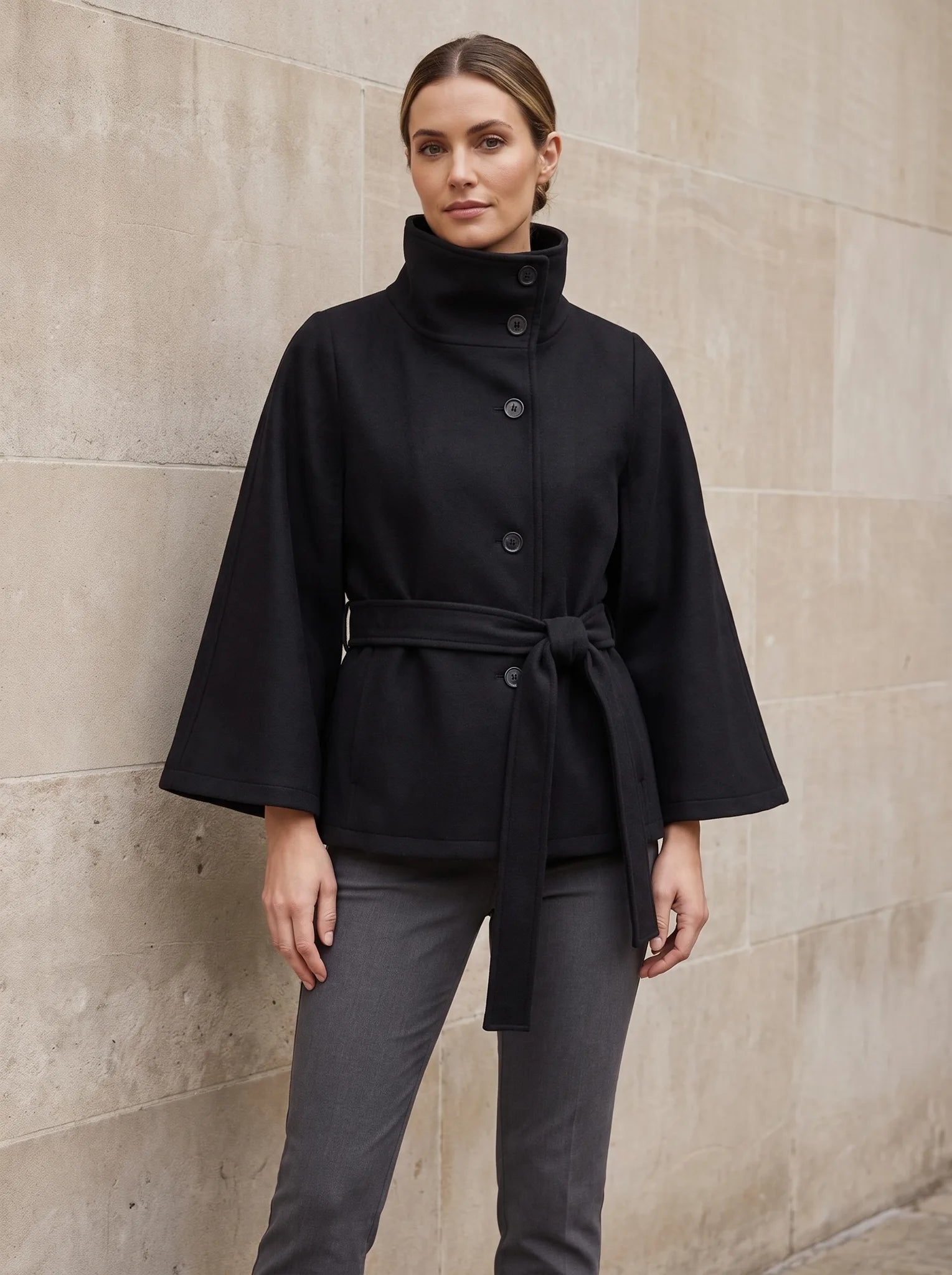 Constance cape-jas met staande kraag in zwart, gedragen door model, vooraanzicht