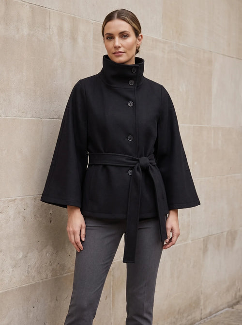 Constance cape-jas met staande kraag in zwart, gedragen door model, vooraanzicht