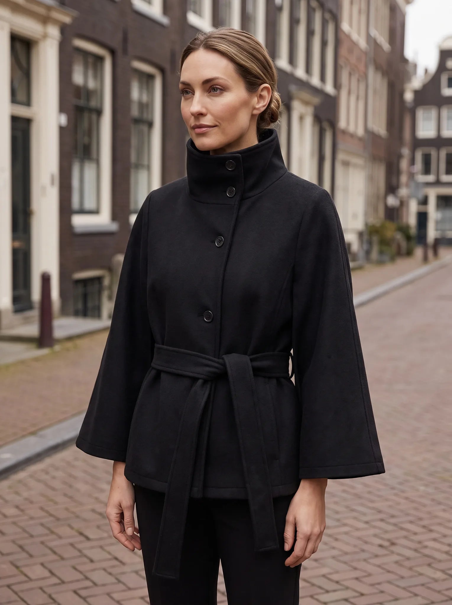 Constance cape-jas in zwart gedragen op straat in de stad