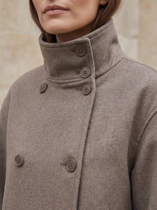 Close-up van de dubbele knooprij en staande kraag van het Odette jasje in taupe