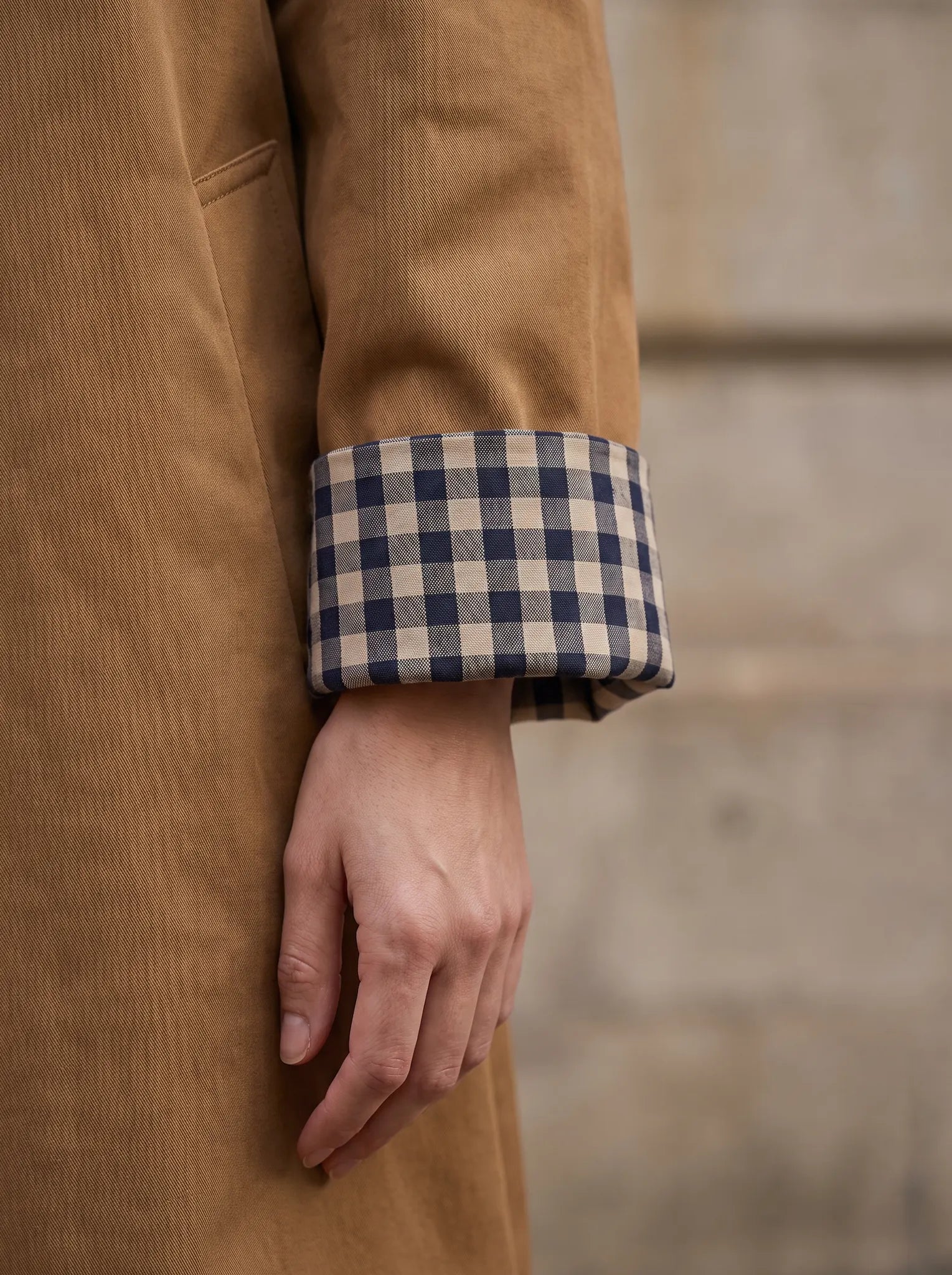 Close-up van de omgeslagen manchet met geruite voering van de Vivienne trenchcoat