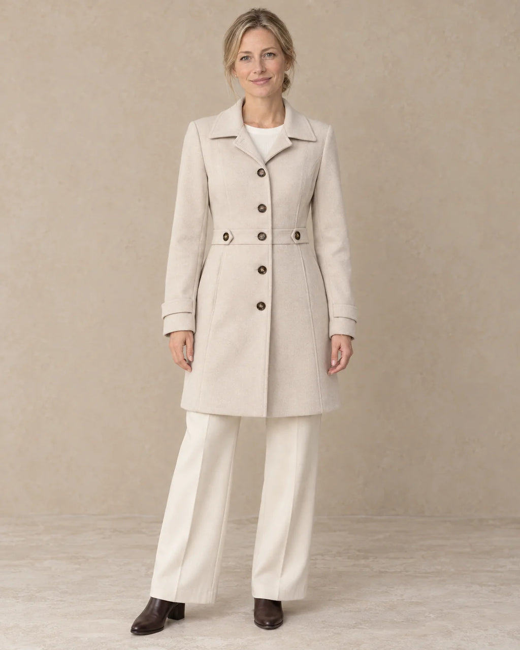 Knielange Getailleerde Jas Dames met Knopen in Beige, gedragen door model, vooraanzicht