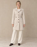Knielange Getailleerde Jas Dames met Knopen in Beige, gedragen door model, vooraanzicht