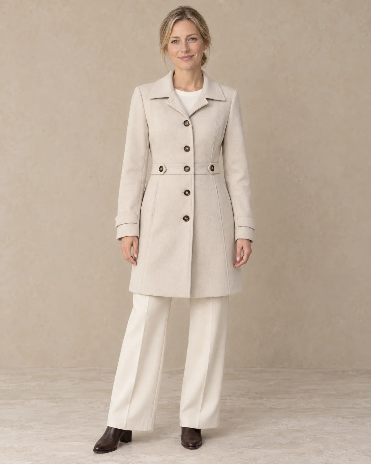 Knielange Getailleerde Jas Dames met Knopen in Beige, gedragen door model, vooraanzicht