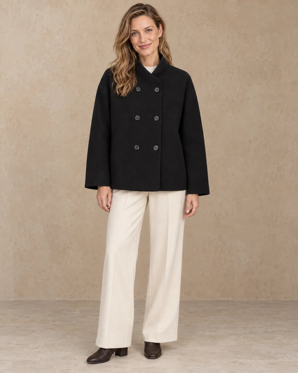 Korte Oversized Dubbelrij Jas Dames in Zwart, gedragen door model, vooraanzicht