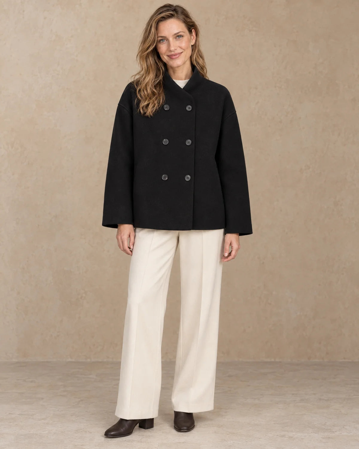 Korte Oversized Dubbelrij Jas Dames in Zwart, gedragen door model, vooraanzicht