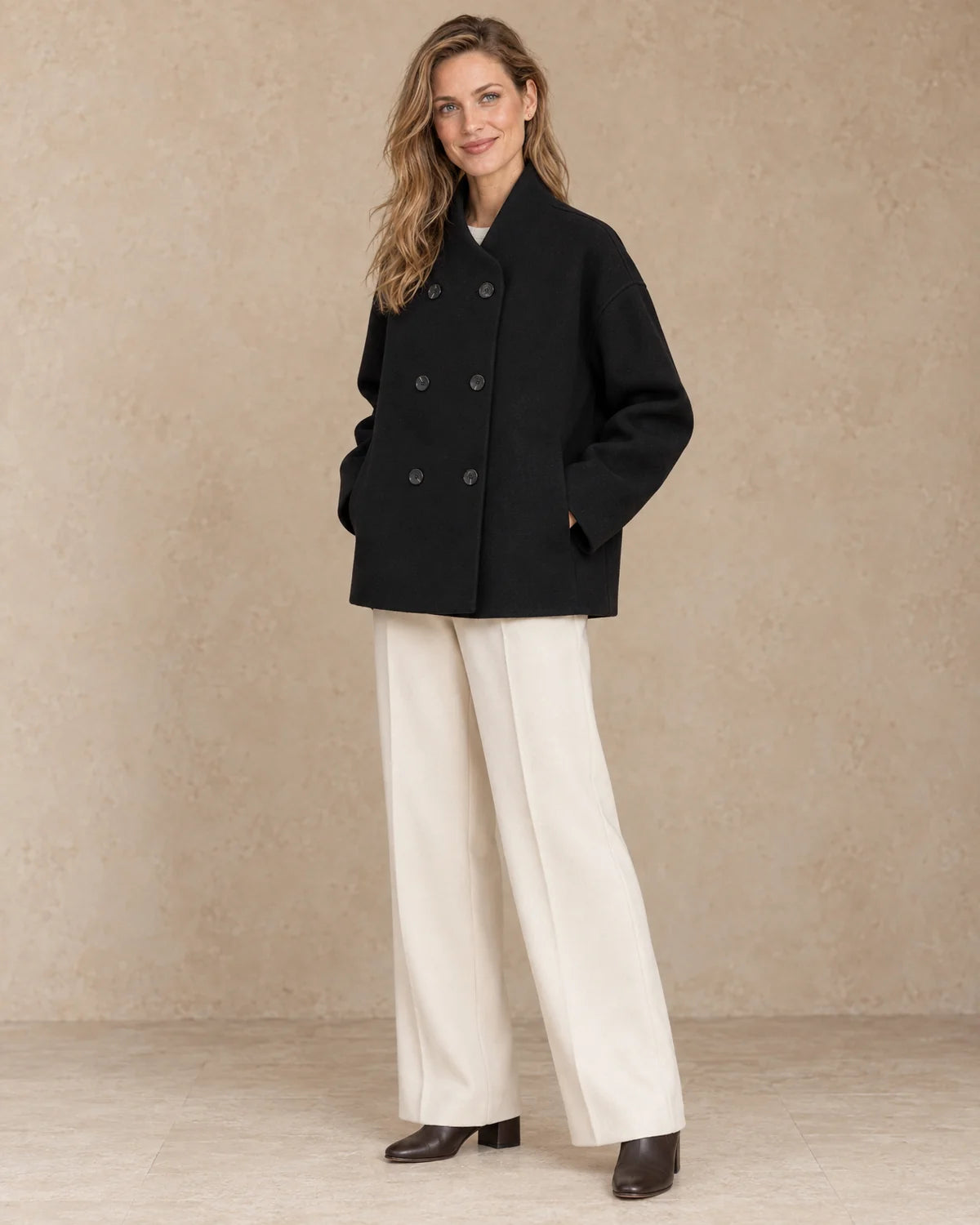 Korte Oversized Dubbelrij Jas Dames in Zwart, gedragen door model, driekwart aanzicht