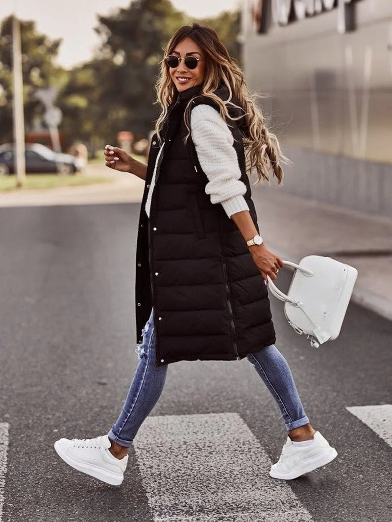 Lange Gewatteerde Bodywarmer Dames met Capuchon in Zwart, gedragen door model, zijaanzicht